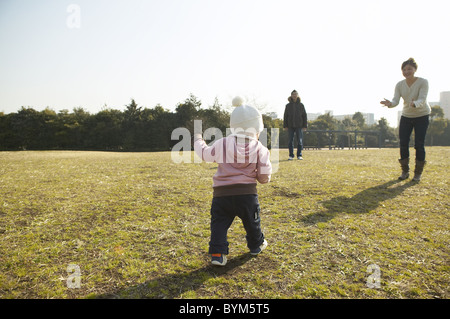 Family of Three Playing in Park Stock Photo