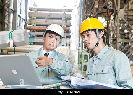 Warehouse Workers Using Laptop Stock Photo