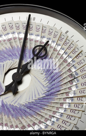 Twenty Pound Notes on Clock Face with Hands Stock Photo