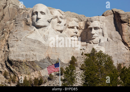 USA, South Dakota, Mount Rushmore National Monument, American flag flies in front of Mount Rushmore carved into Black Hills