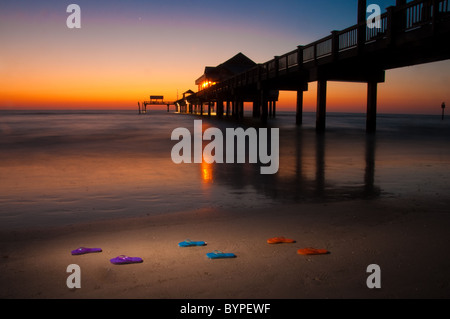 Pier 60 on Clearwater Beach, Florida. Flip flops in foreground repeat color in the sky. Stock Photo