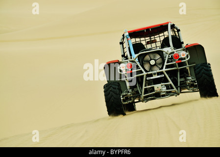 Rear of ATV dune buggy driving on yellow sand dunes in arid Namib desert Swakopmund Namibia Sport Travel Transportation action Stock Photo