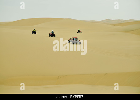 ATVs on desert adventure tour looking isolated in vastness of sand, Swakopmund Namibia Stock Photo
