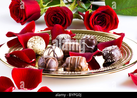 Gold plate of luxury chocolates with red roses Stock Photo