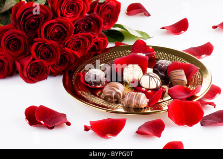 Gold plate of luxury chocolates with red roses Stock Photo