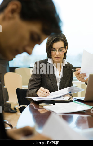 Executives reviewing documents in meeting Stock Photo