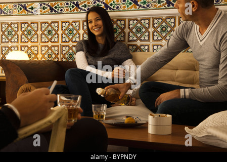 Friends hanging out together in living room Stock Photo