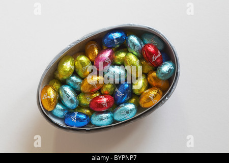 Lindt miniature easter eggs in coloured foil wrappers in easter egg half container Stock Photo
