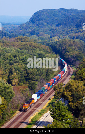 A BNSF Railway intermodal train rolls under the bluffs of the Mississippi River valley near Savanna, IL. Stock Photo
