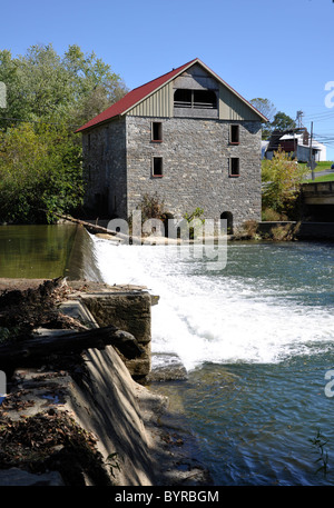 Old stone grist mill by a dam and waterfall.  The grist mill is in Lehigh County, Pennsylvania Stock Photo