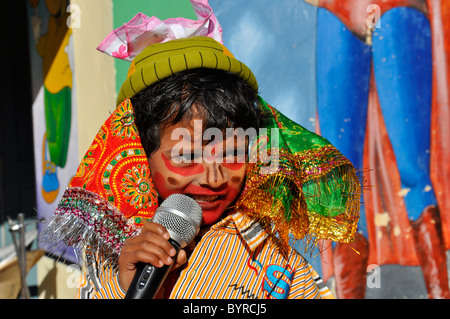 An indian boy dressed as a clown speaking on mike Stock Photo