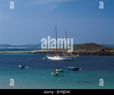 A schooner moored in the channel between the islands of St Martin's and Tresco, Scilly Isles, UK. Old Grimsby in the distance Stock Photo