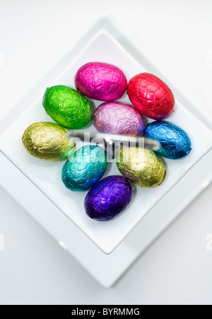 A small selection of mini chocolate eggs in a white dish Stock Photo