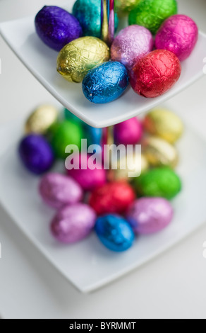 A small selection of mini chocolate eggs in a white dish Stock Photo
