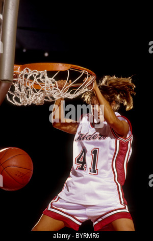 Female basketball player slam dunking. Stock Photo
