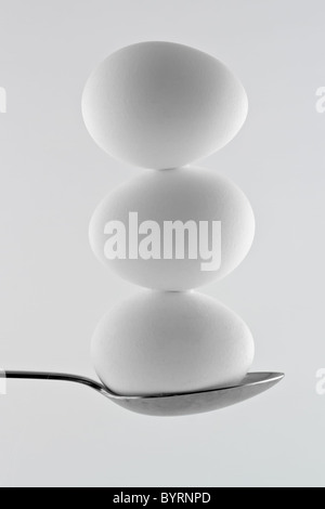 Three white eggs balancing on a spoon Stock Photo
