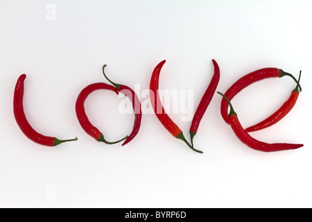 Red hot chili peppers arranged as the word LOVE on white background Stock Photo
