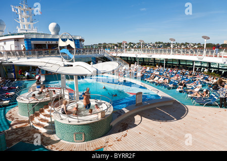 Senior men and women sit in hot tub and on lounge chairs on the deck of Royal Caribbean's Jewel of the Seas cruise ship Stock Photo