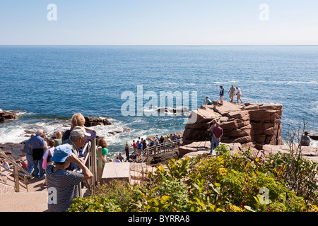 Tourists walking down the Rocky coastline at Thunder Hole in Acadia National Park near Bar Harbor, Maine Stock Photo