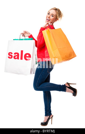 Attractive young woman looking happing holding shopping bags displaying the sale sign Stock Photo