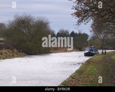Stratford upon Avon canal near Wootton Wawen, frozen in winter, with barge. Warwickshire, UK, January 2011 Stock Photo