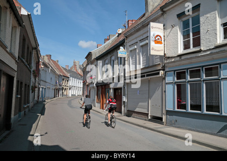 Two cyclists on an empty Rue Constant Moeneciaey in Cassel, France. Stock Photo