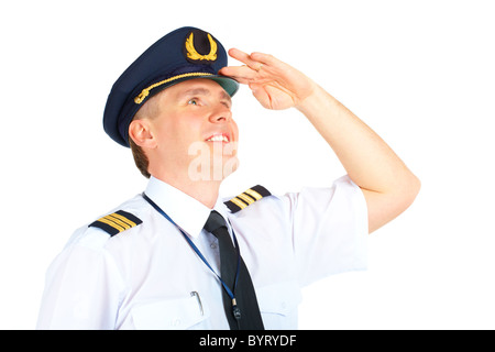 Cheerful airline pilot wearing uniform with epaulets and hat looking upwards, standing isolated on white background. Stock Photo