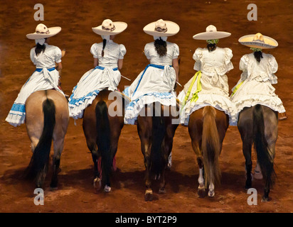 Women horse riders wearing traditional Escaramuza Charra costumes at Lienzo Charro charreada show, Guadalajara, Mexico. Stock Photo