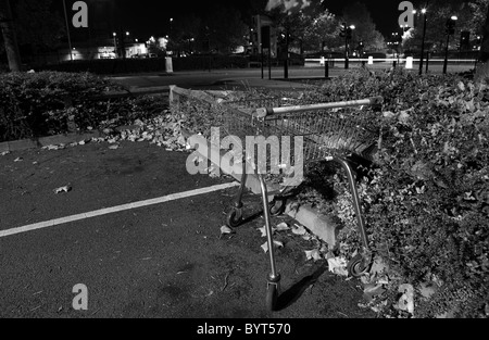 Shopping trolley left in street at night Stock Photo