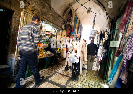 Orthodox Jewish men walking through the vibrant markets of the Muslim quarter in the old city of Jerusalem. Stock Photo
