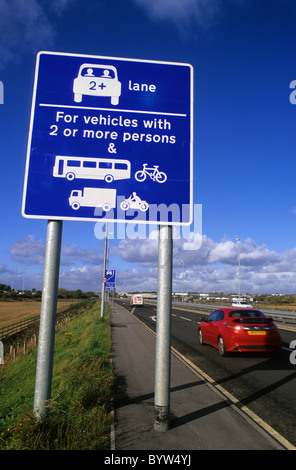 car passing warning roadsign of high occupancy lane ahead for vehicles carrying two or more people to ease congestion Leeds UK Stock Photo