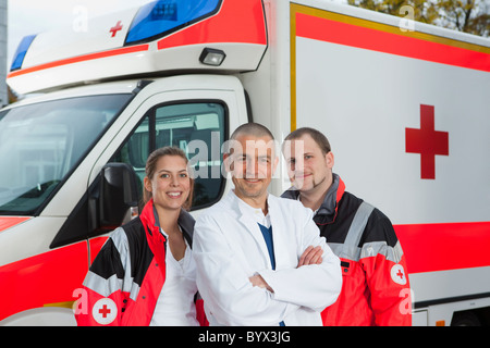 Doctor and paramedics in front of coach Stock Photo