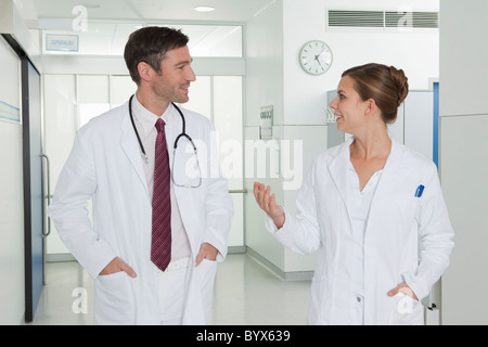 Nurse and doctor discussing in hall Stock Photo
