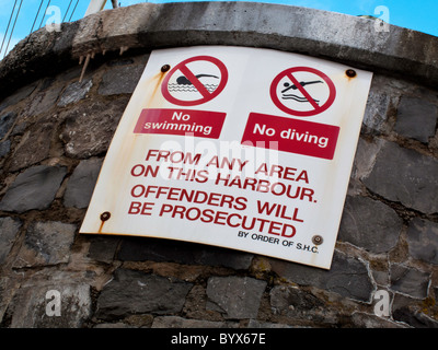 WARNING SIGNS ON SAUNDERSFOOT HARBOUR WALL, PEMBROKESHIRE WALES UK Stock Photo