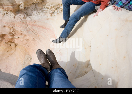 women wearing boots resting on sandstone, high desert of New Mexico, USA Stock Photo