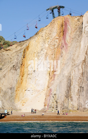 Cable cars taking people down over the multicoloured cliffs onto the beach at Alum Bay on the Isle of Wight Stock Photo