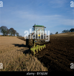 John Deere tractor ploughing winter stubble with a reversible coulter plough Stock Photo