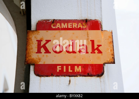 Rusty old fashioned metal sign advertising Kodak cameras and film. Stock Photo