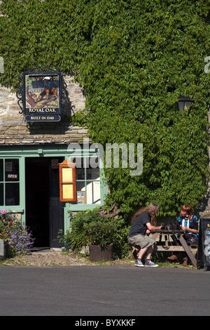 Couple enjoying a drink at the Royal Oak in Cerne Abbas, Dorset in June Stock Photo