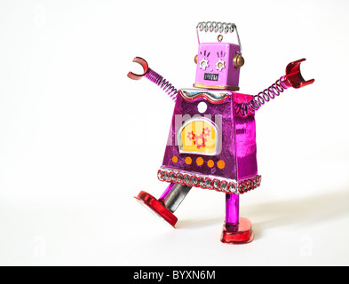 Tin toy robot dancing, with arms raised, (conceptual image), female likeness. Stock Photo
