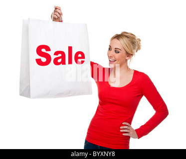 Attractive young woman looking happing holding shopping bags displaying the sale sign Stock Photo