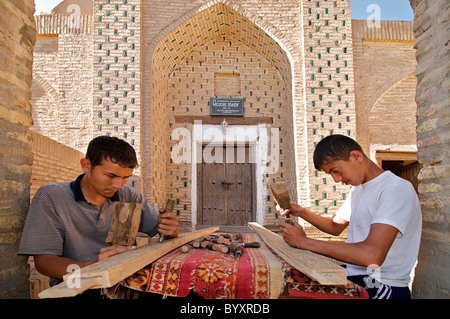 Wood carvers working outside a Madassah, Khiva, Uzbekistan Stock Photo
