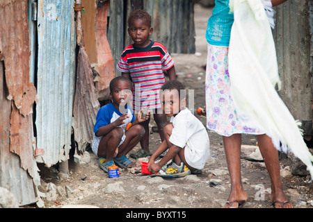 a woman standing with three young boys as they play outside; port-au-prince, haiti Stock Photo