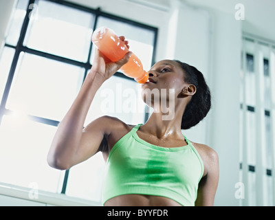 young african american woman in sportswear with energy drink in gym. Horizontal shape, waist up, low angle view Stock Photo