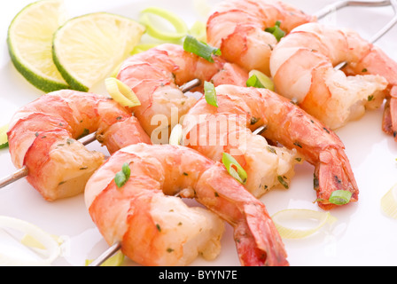 Prawn skewer with king prawns and leek as closeup on a white plate Stock Photo