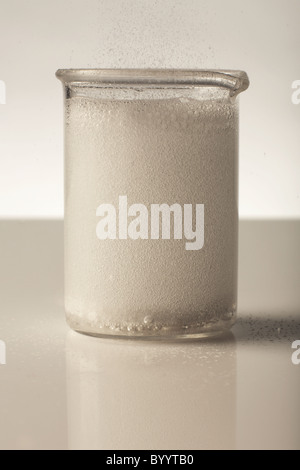 Lab Beaker Overflow effervescent table dropped in a laboratory beaker full with water ...