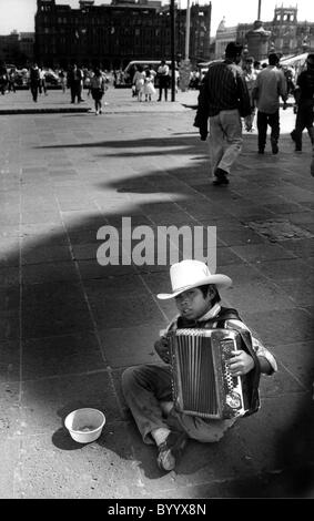 Young boy playing accordion and  begging in streets of Mexico City Stock Photo