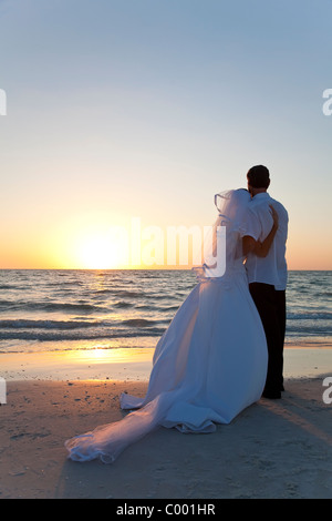 Wedding of a married couple, bride and groom, together at sunset on a beautiful tropical beach Stock Photo