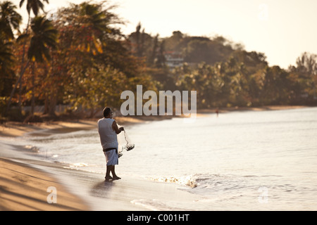 A fisherman prepares his cast net on Corcega Beach in Rincon, Puerto Rico. Rincon is one of the surf capitals of the world. Stock Photo