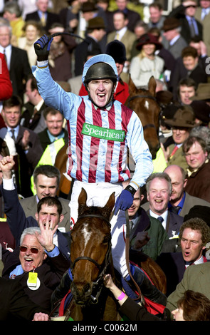 Jockey Tony McCoy celebrates victory on Edredon Blue in the Queen Mother Champion Chase with owner Jim Lewis (bottom left) . Stock Photo